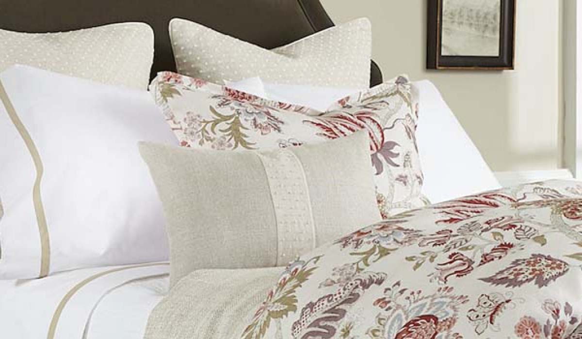A tailored custom bed with coordinated bedding and upholstered details