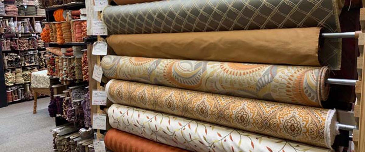 Bolts of upholstery and drapery fabric arranged by color